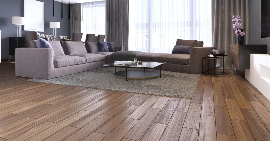 Modern living room with wood flooring, gray sofas, area rug, and coffee table by large windows